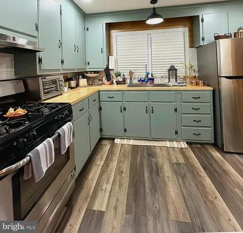 a kitchen with stainless steel appliances a stove a sink and a refrigerator