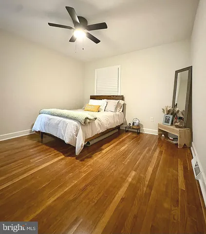a spacious bedroom with a bed and wooden floor
