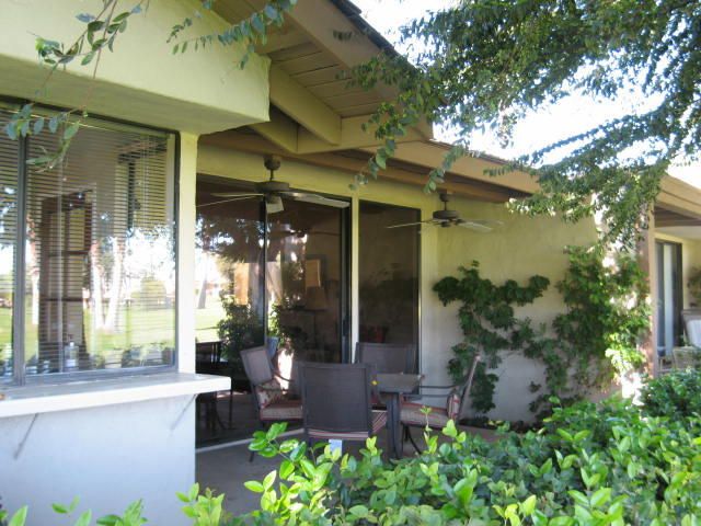 front view of a house with potted plants and a fountain