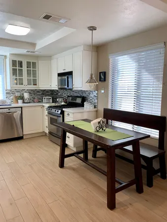 a kitchen with a table chairs stove and cabinets