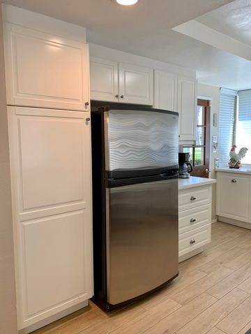 a kitchen with refrigerator cabinets and wooden floor