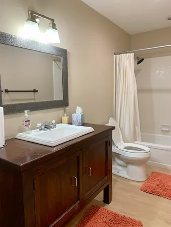 a bathroom with a granite countertop sink toilet and shower