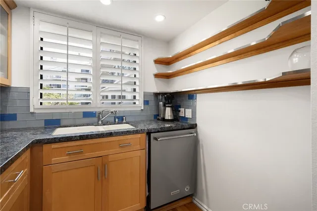 a kitchen with granite countertop cabinets sink and window