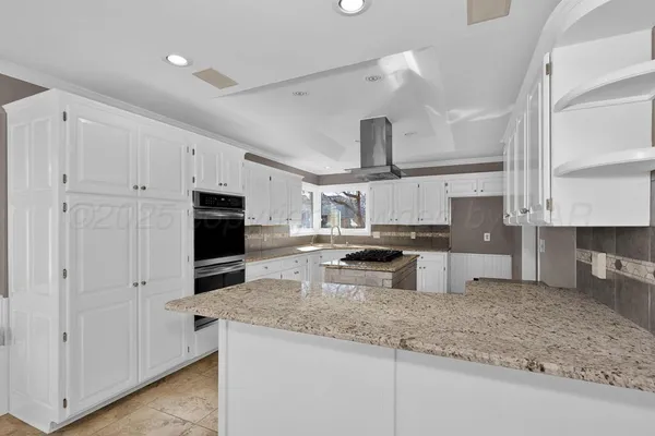 a kitchen with stainless steel appliances granite countertop a sink a stove and a refrigerator