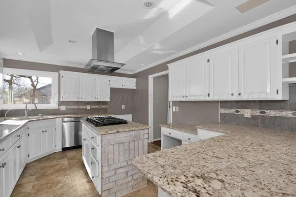 a kitchen with granite countertop a sink and cabinets