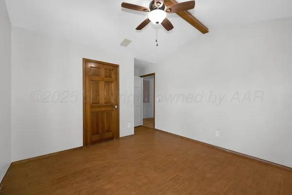 an empty room with closet and a chandelier fan