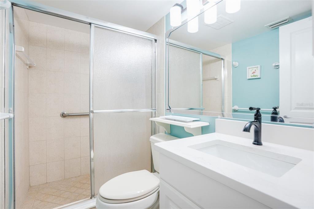 18304 Gulf Boulevard, Unit 105 Redington Shores, FL 33708 - Photo 22 of 33 a bathroom with a sink a toilet and shower