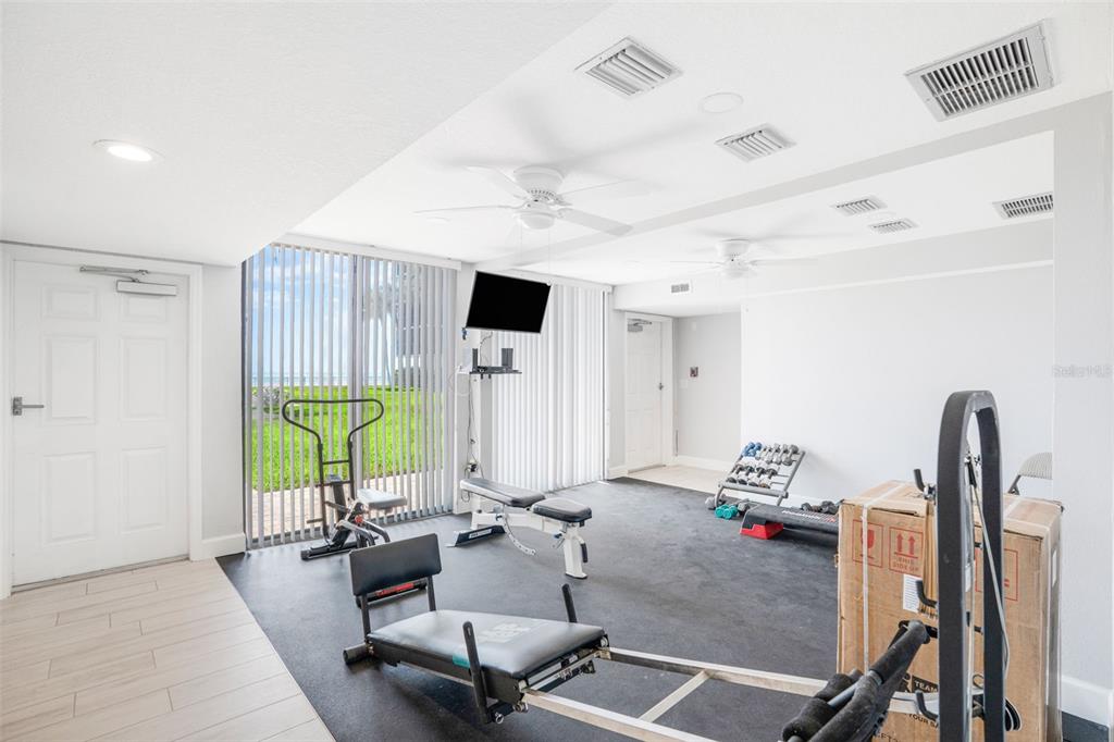 18304 Gulf Boulevard, Unit 105 Redington Shores, FL 33708 - Photo 31 of 33 a living room with furniture a window and gym equipment