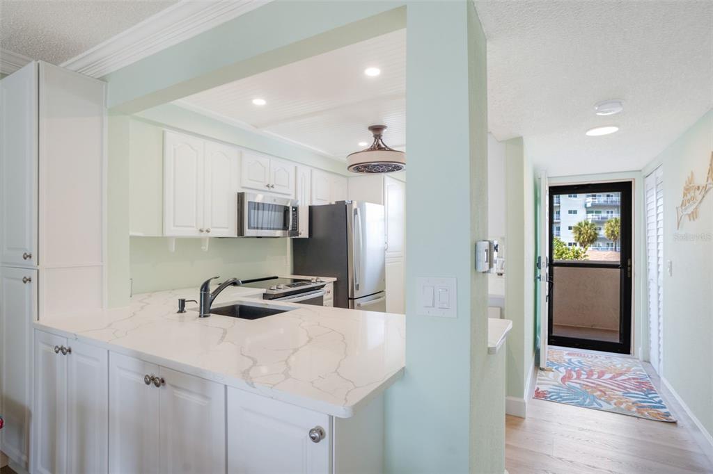 18304 Gulf Boulevard, Unit 105 Redington Shores, FL 33708 - Photo 5 of 33 a kitchen with stainless steel appliances a sink stove and refrigerator