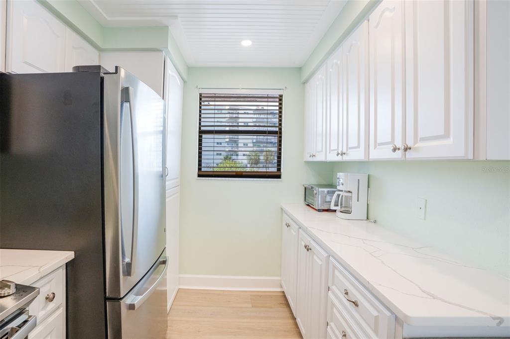 18304 Gulf Boulevard, Unit 105 Redington Shores, FL 33708 - Photo 7 of 33 a kitchen with stainless steel appliances granite countertop a refrigerator and a sink