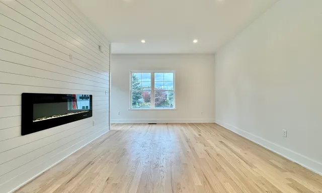 an empty room with wooden floor and fireplace