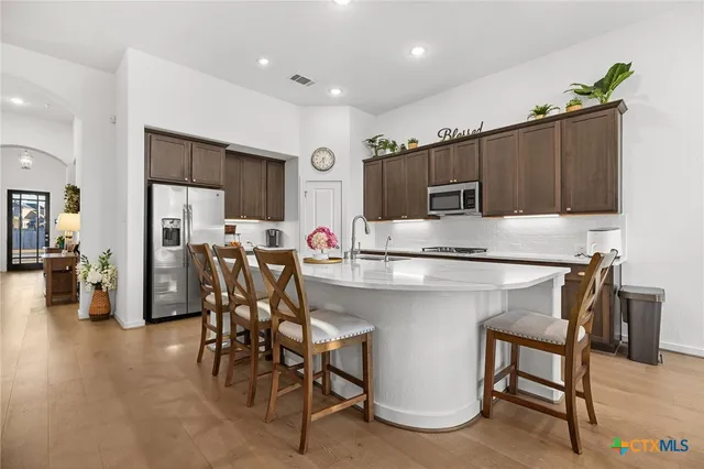 a kitchen with a table chairs refrigerator and microwave