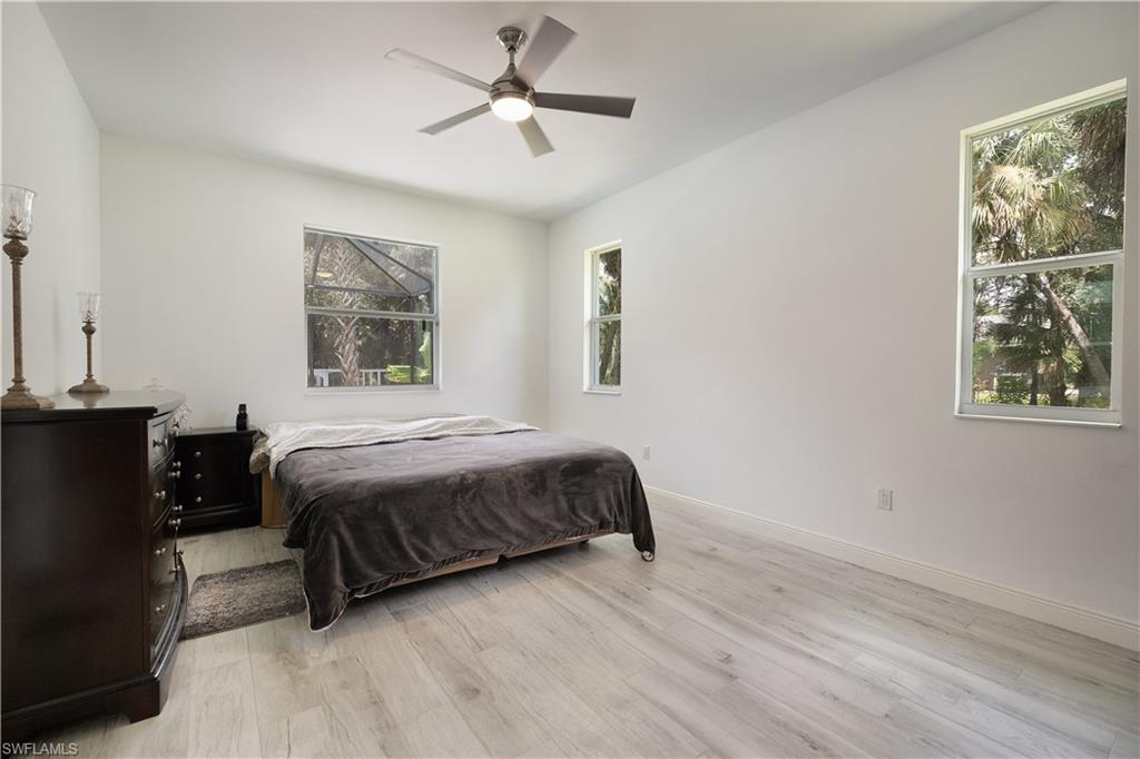 693 7th Street Northwest Naples, FL 34120 - Photo 16 of 32 a bedroom with a bed a window and painting on the wall