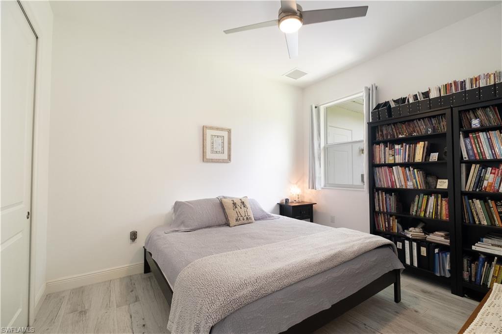 693 7th Street Northwest Naples, FL 34120 - Photo 18 of 32 a bedroom with a bed and a book shelf