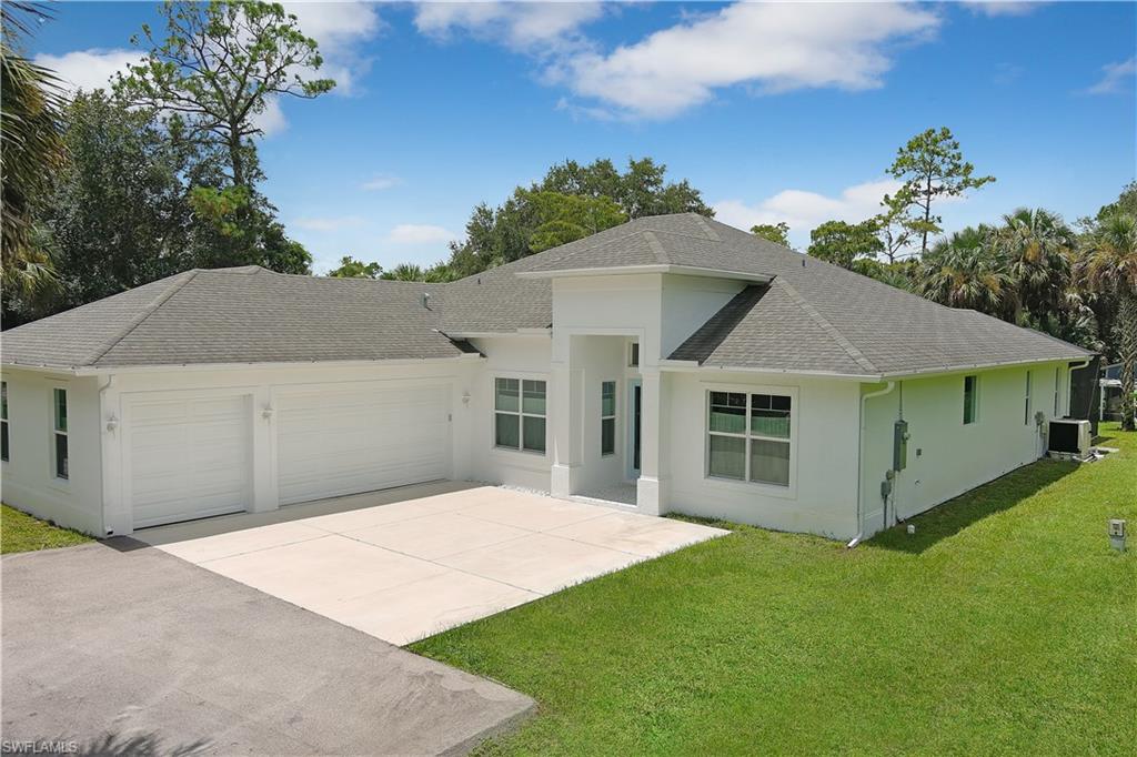 693 7th Street Northwest Naples, FL 34120 - Photo 4 of 32 a front view of a house with a garden