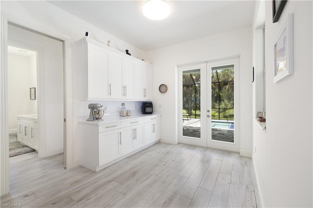 693 7th Street Northwest Naples, FL 34120 - Photo 10 of 32 a large white kitchen with dishwasher a stove a refrigerator with white cabinets and wooden floor