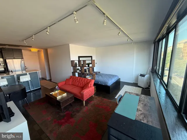 a living room with furniture a rug and a large window