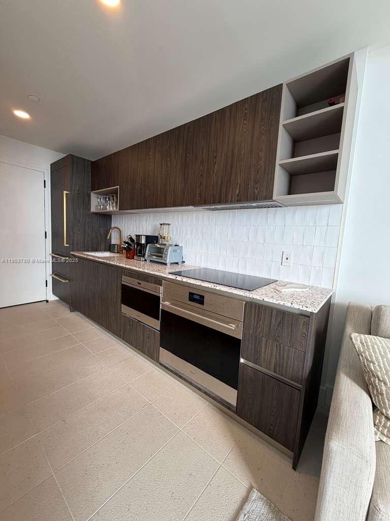 159 Northeast 6th Street, Unit PH5014 Miami, FL 33132 - Photo 12 of 41 a kitchen with a stove and a microwave