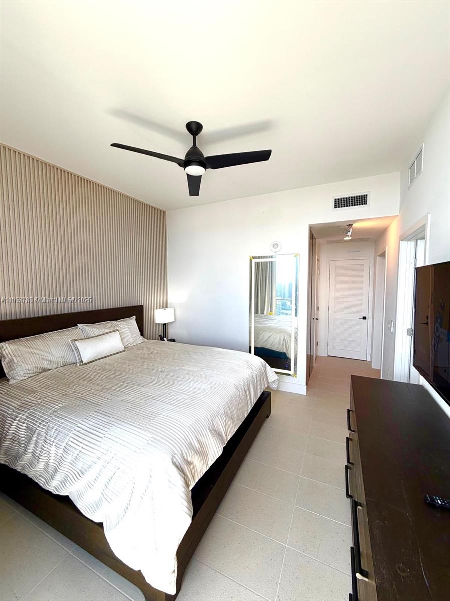 159 Northeast 6th Street, Unit PH5014 Miami, FL 33132 - Photo 17 of 41 a spacious bedroom with a bed and a flat screen tv