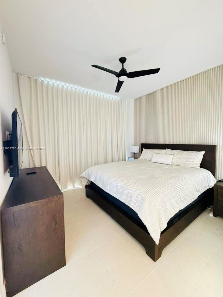 159 Northeast 6th Street, Unit PH5014 Miami, FL 33132 - Photo 19 of 41 a bedroom with a bed and a chandelier
