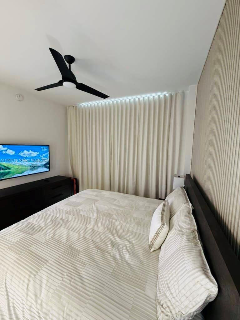 159 Northeast 6th Street, Unit PH5014 Miami, FL 33132 - Photo 20 of 41 a bed sitting in a bedroom next to a window