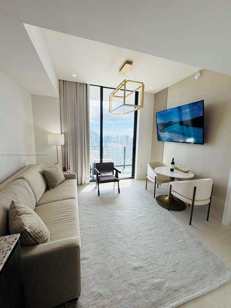 159 Northeast 6th Street, Unit PH5014 Miami, FL 33132 - Photo 9 of 41 a living room with furniture and a flat screen tv