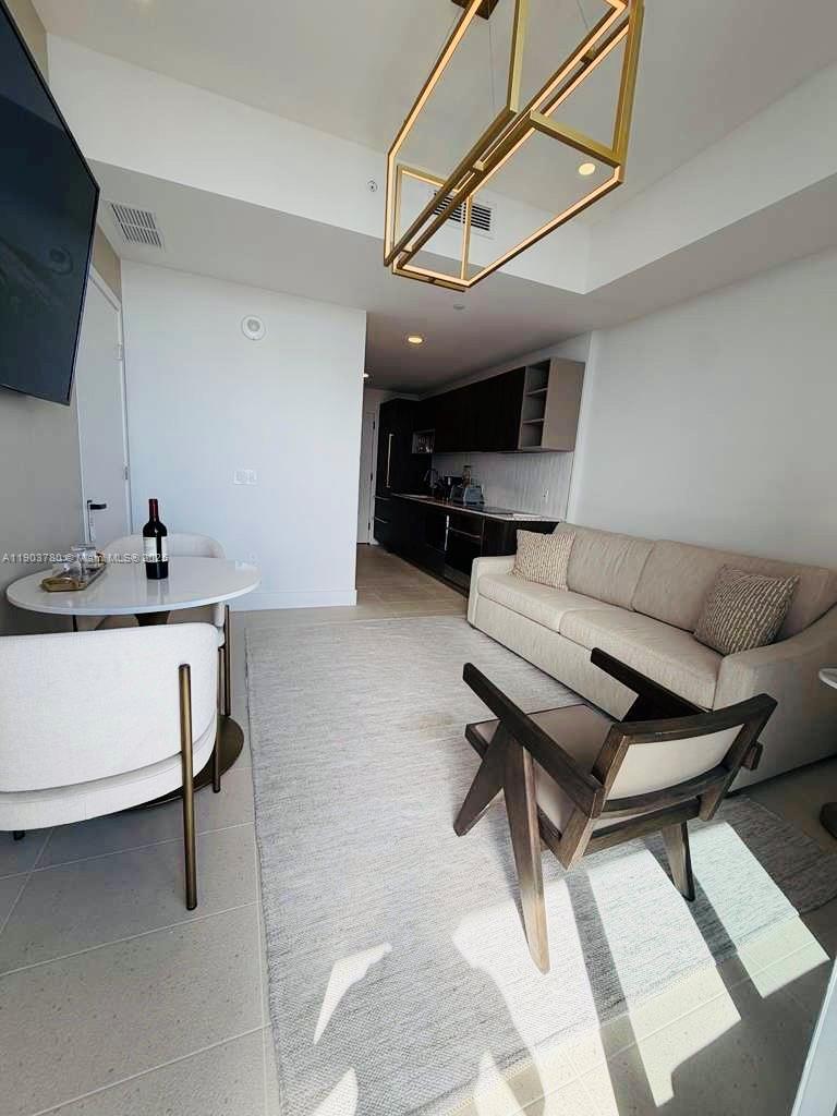 159 Northeast 6th Street, Unit PH5014 Miami, FL 33132 - Photo 10 of 41 a living room with furniture and a flat screen tv