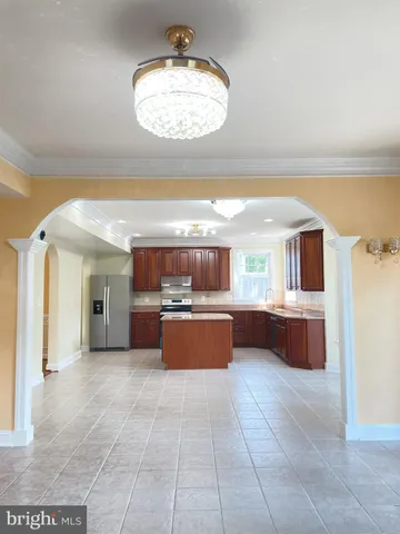 a large kitchen with a large counter top and stainless steel appliances
