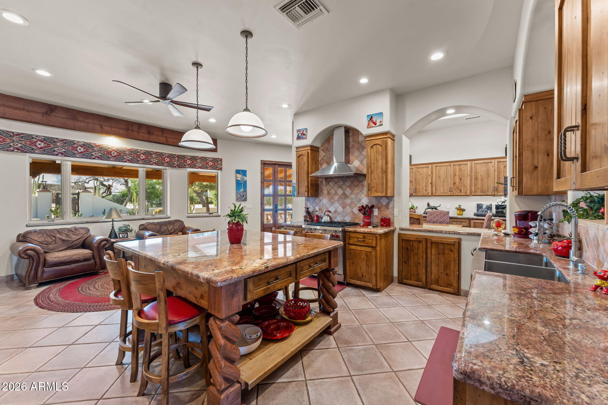 18210 Moonlight Mesa Road Wickenburg, AZ 85390 - Photo 11 of 141 a kitchen with stainless steel appliances kitchen island granite countertop a stove a sink and a refrigerator