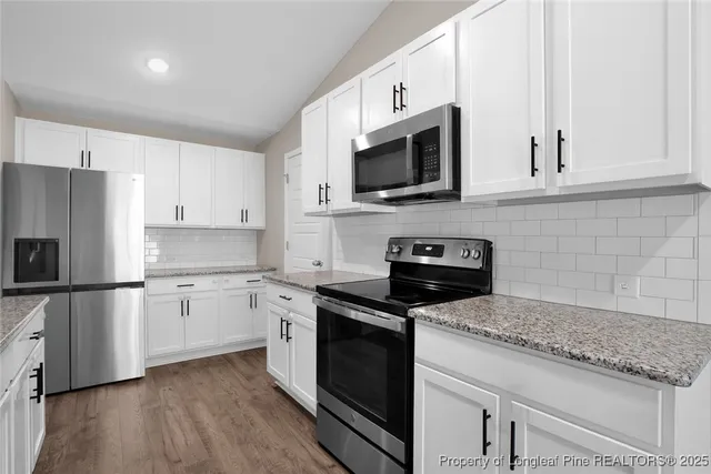 a kitchen with white cabinets and stainless steel appliances
