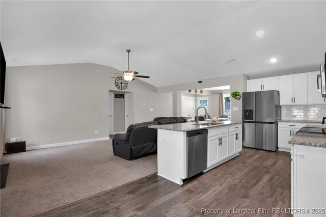 a kitchen with a refrigerator a stove top oven a counter space and cabinets
