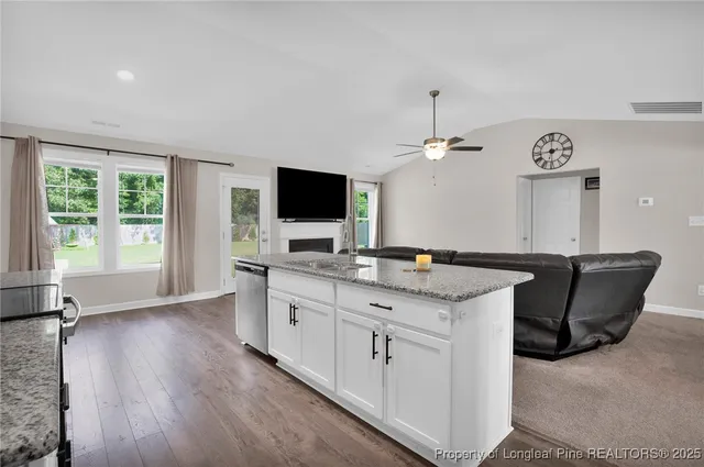a kitchen with granite countertop a sink and a stove top oven