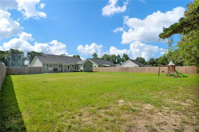 a view of yard with swimming pool and seating space