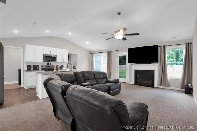 a living room with furniture a fireplace and a flat screen tv