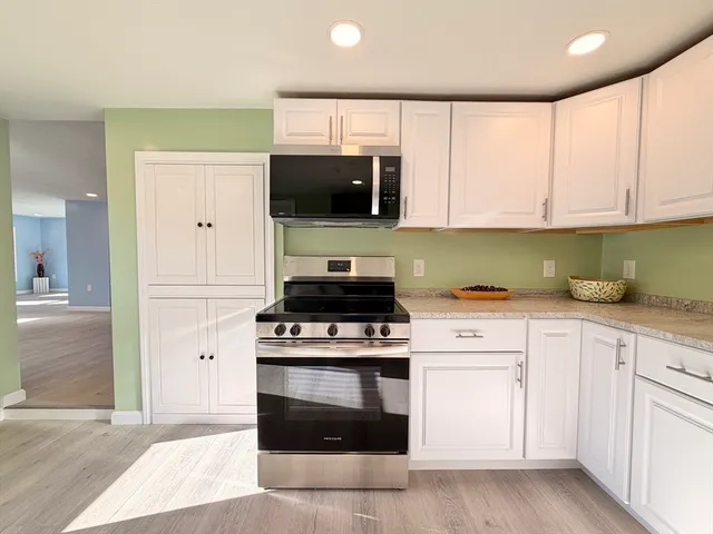 a kitchen with white cabinets and stainless steel appliances