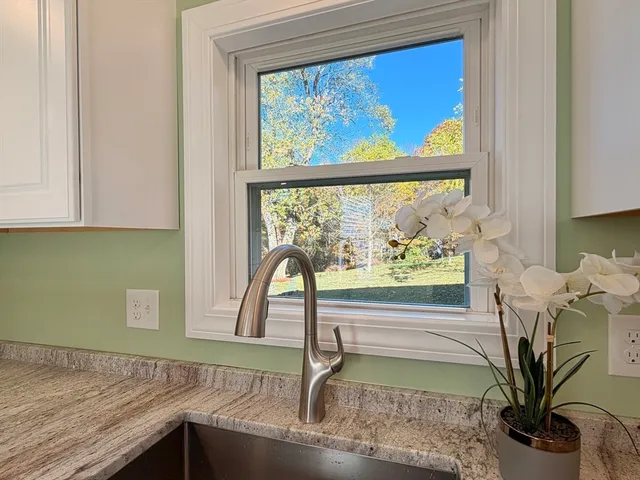 a view of a living room with a floor to ceiling window and wooden floor