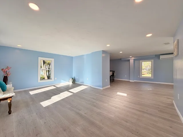 a view of a livingroom with a window and wooden floor
