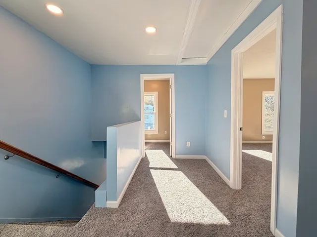 a view of a hallway with windows and closet