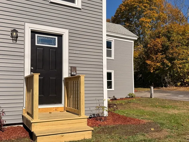 a view of a house with a door and a tree