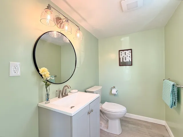 a bathroom with a sink a toilet and a mirror