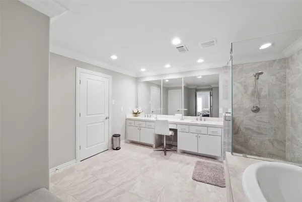 a large bathroom with a tub sink shower and mirror