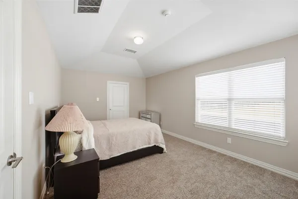 a spacious bedroom with a bed and a window