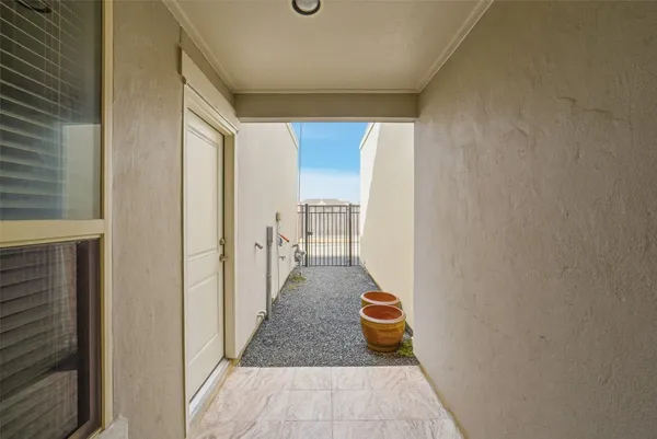 a view of a hallway with wooden floor and a refrigerator