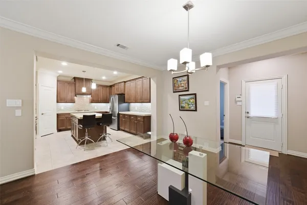 a view of a dining room and livingroom with furniture wooden floor a chandelier