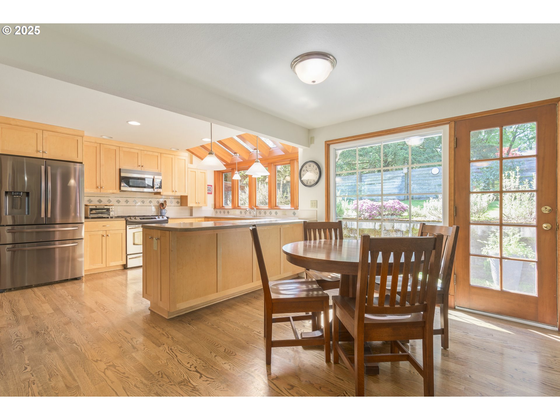 888 Crest Drive Eugene, OR 97405 - Photo 11 of 48 a dining room with stainless steel appliances a dining table wooden floor and a large window