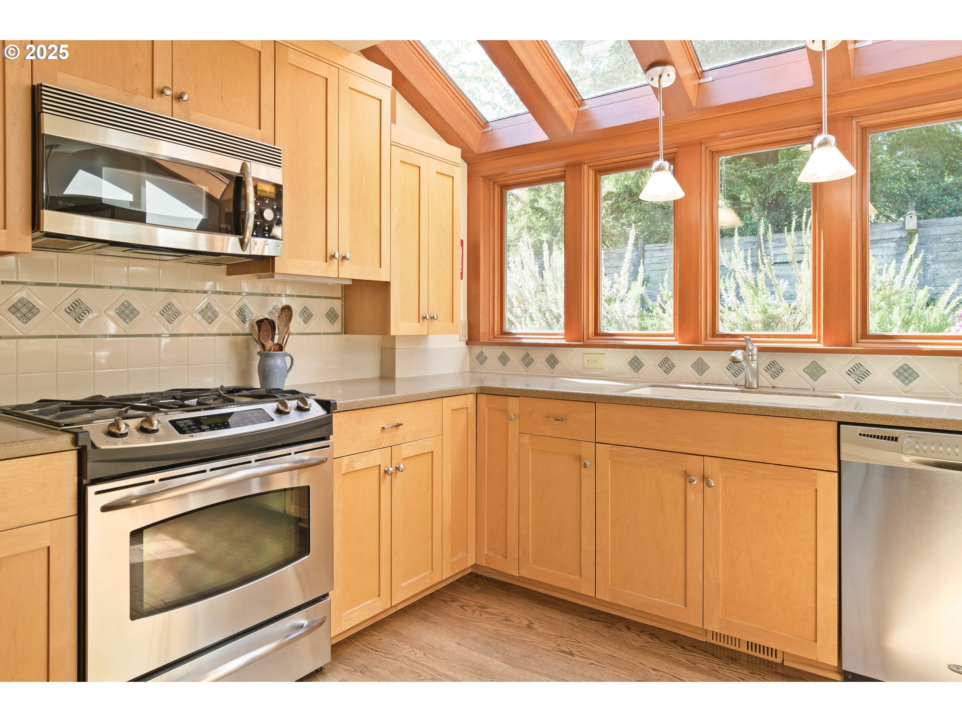 888 Crest Drive Eugene, OR 97405 - Photo 8 of 48 a kitchen with stainless steel appliances granite countertop a stove a sink and a microwave