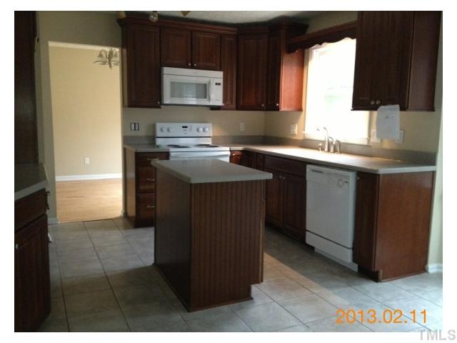 6617 Hammersmith Drive Raleigh, NC 27613 - Photo 3 of 13 a kitchen with stainless steel appliances granite countertop a stove a sink and a microwave