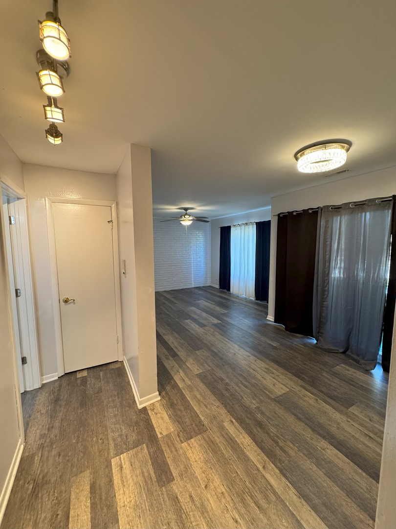 6027 103rd Street, Unit 1A Chicago Ridge, IL 60415 - Photo 17 of 22 a view of an empty room with wooden floor and window