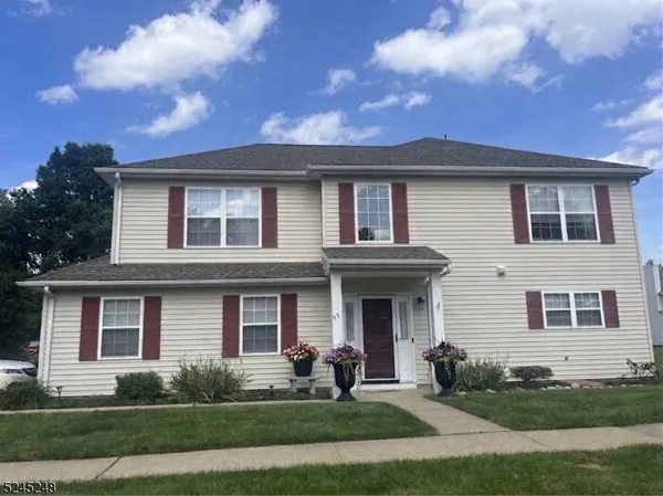 a front view of a house with yard and green space