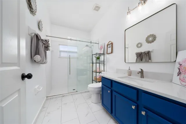 a bathroom with a double vanity sink toilet mirror and shower